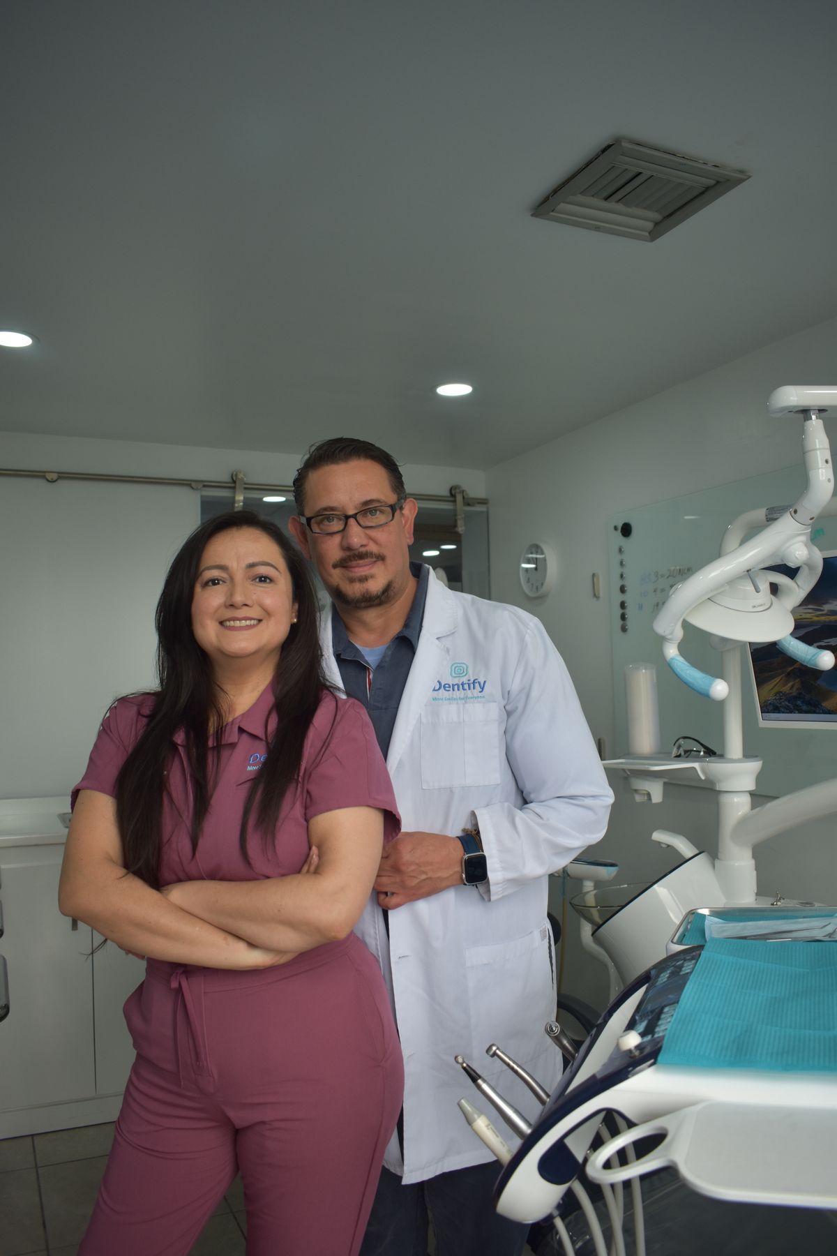 Dentistas sorrindo em clínica odontológica moderna